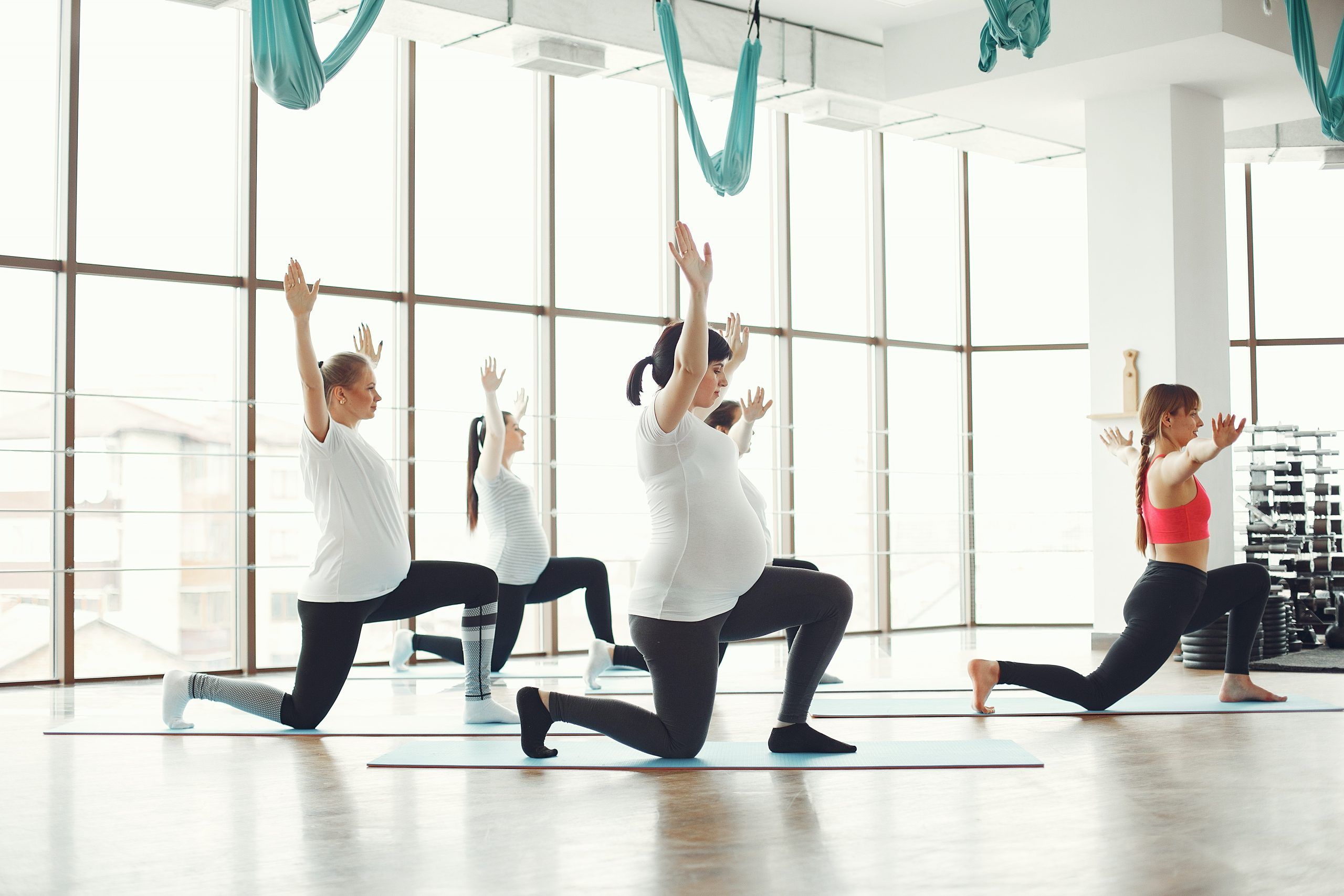 pregnant-women-doing-yoga-in-spacious-studio-3984357
